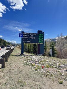 Breckenridge parking availability sign beside the highway approach into town, mountains behind