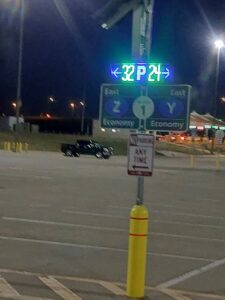 Solar-powered LED parking count sign glowing at night in the East Economy lot at Denver International Airport