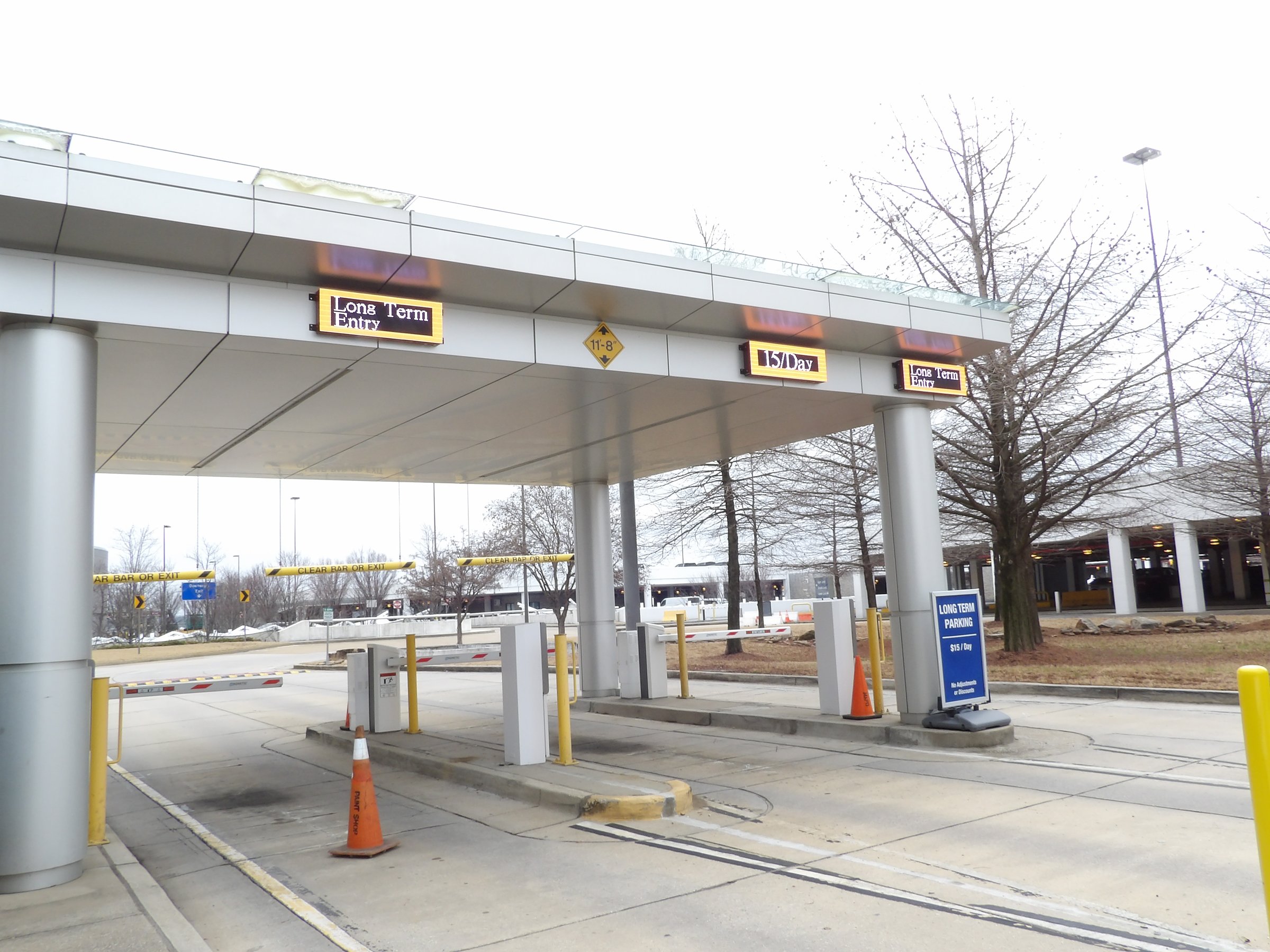 Amber LED lane signs under the long-term parking entry canopy at Memphis International Airport showing entry lanes and the daily rate