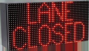 Product shot of a compact red LED sign displaying LANE CLOSED